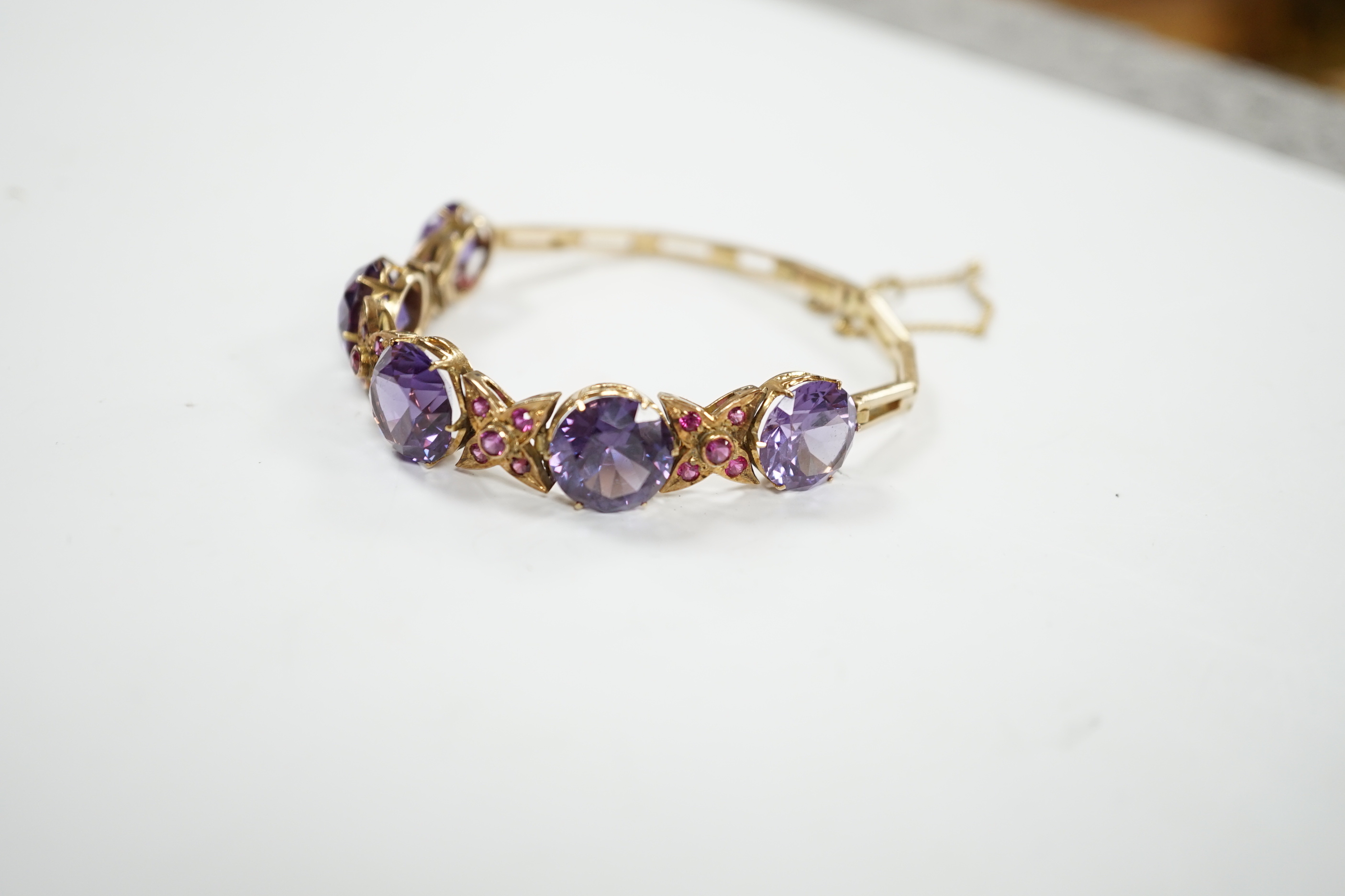 A yellow metal, synthetic colour change corundum and gem set bracelet. approx. 18cm, gross weight 22.7 grams.